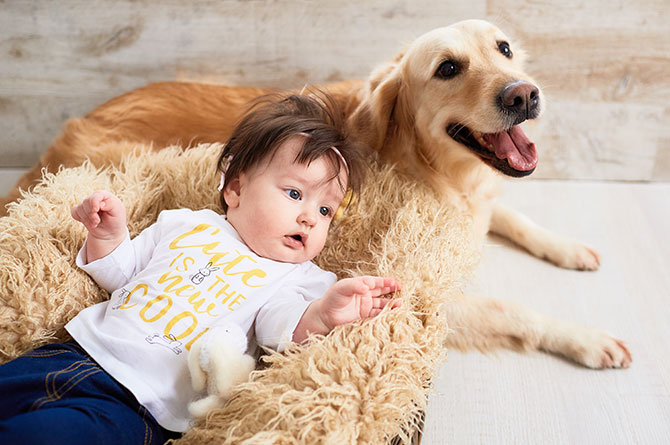 Hund ligger sammen med baby på gulvet